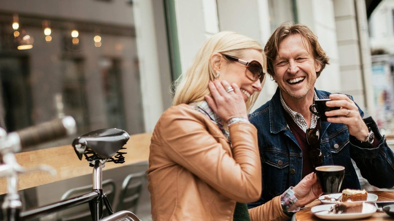 couple laughing drinking coffee