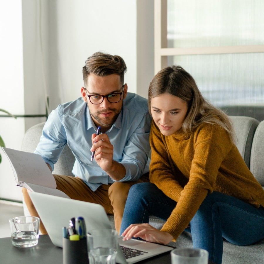 couple using laptop on sofa