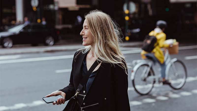 woman holding mobile in street